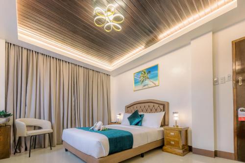 a hotel room with a bed and a chair at Loboc Riverside Inn & Restaurant in Loboc