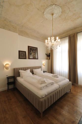 a large bed in a bedroom with a chandelier at Apartmá Juliana 1905 in Karlovy Vary