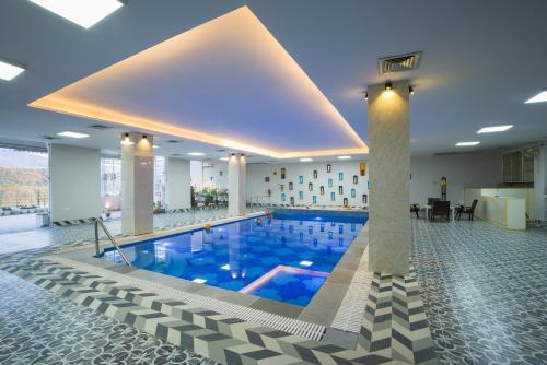 Una gran piscina en el vestíbulo de un hotel. en ELIVAAS BYDM The Ganges 2 BHK Glasshouse Villa With Pvt Pool & Lift, en Rishīkesh