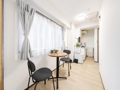 a small table and chairs in a room with a window at Shibuya Area ,Ebisu 3min walk,Harajuku 2min,Queen Bed,Switch,Free Wi-Fi , PocketWi-Fi in Tokyo