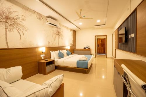 a hotel room with a bed and a couch at West Bay MARISOL in Varkala