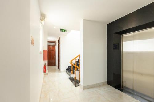 a hallway with a white wall and a door at AM Memory Central Hotel 2 in Da Lat