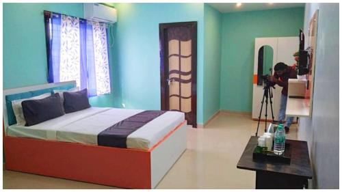 a bedroom with a bed with a camera on a tripod at HOTEL SUPERIOR DREAMZ HEAVEN Near Temple in Kedihāti