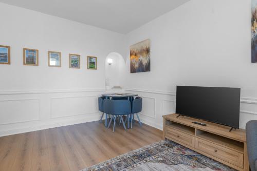 a living room with a tv and a blue chair at Luxury Central Hidden Gem in Musselburgh