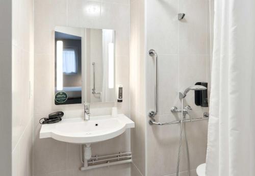 a white bathroom with a sink and a shower at B&B HOTEL Noisy-le-Grand in Noisy-le-Grand