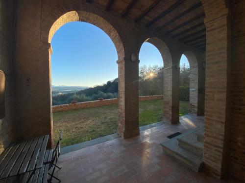 an archway in a building with a bench and a view at CasaLeTolfe Residence in Siena