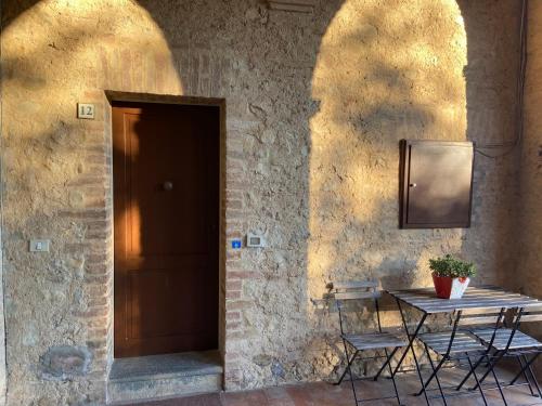a table and chairs in front of a door at CasaLeTolfe Residence in Siena