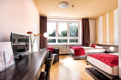 a hotel room with a bed and a desk and a bedroom at Hotel Grenzfall in Berlin