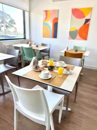 a dining room with tables and chairs with food and orange juice at Residencial Dona Teresa in Maia