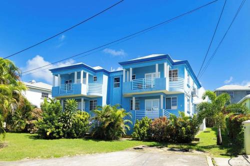 a blue and white house with palm trees in front of it at St Silas 3-bedroom by ZenBreak in Saint James