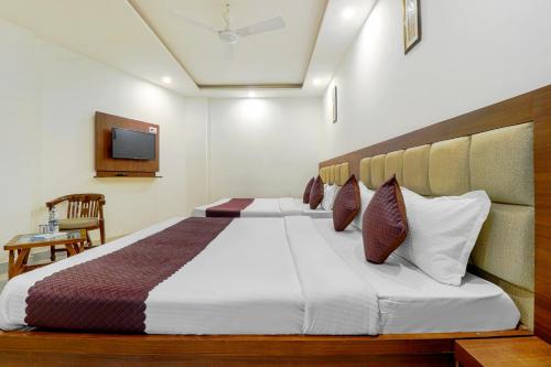 a bedroom with a large bed and a television at La Olivia in Haridwār