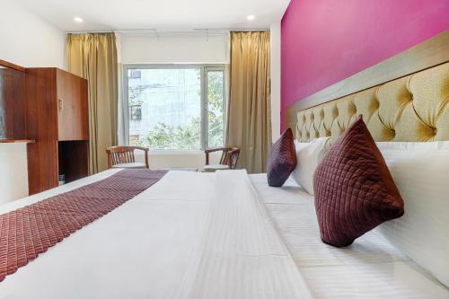 a bedroom with a large bed and a pink wall at La Olivia in Haridwār