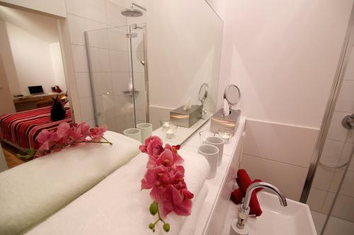 a bathroom with a sink and a shower with flowers on it at Ferienwohnung "Karmeliten Am Dom" in Regensburg