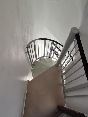 a spiral staircase in a building with a white wall at À 18min du ZOO 30min des 24h du Mans in Le Lude