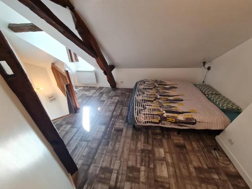 a bedroom with a bed and a wooden floor at À 18min du ZOO 30min des 24h du Mans in Le Lude