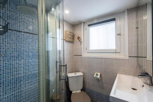 a bathroom with a shower and a toilet and a sink at L'Anisé - Maison climatisée in Martigues
