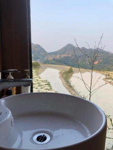 a bathroom sink with a view of a dirt road at Sunrise Camping Ha Giang Lung Cu in Ha Giang
