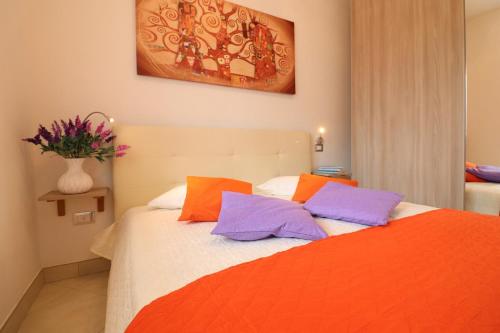 a bedroom with a bed with orange and purple pillows at Casa Francesca Otranto Modern 3 Guest Flat with AC & WiFi in Otranto