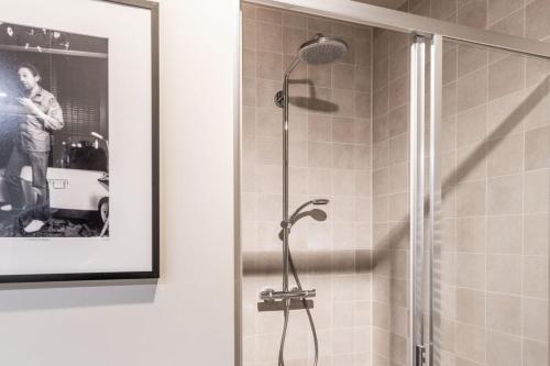 a shower in a bathroom with a picture of a man at Mare by Room of in Cadzand