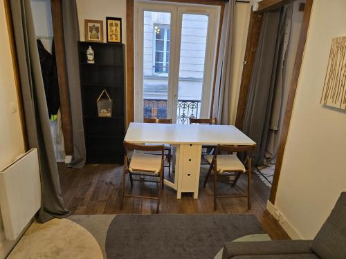 une salle à manger avec une table et des chaises et une fenêtre dans l'établissement Écrin au cœur de Paris, à Paris