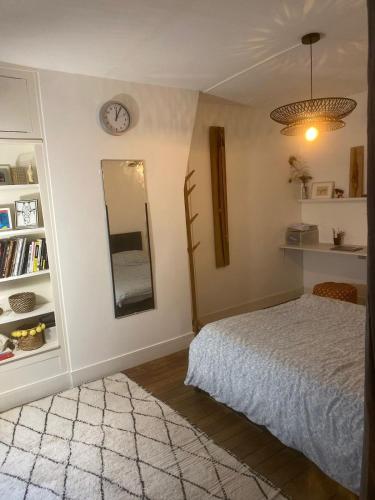 une chambre avec un lit et une horloge au mur dans l'établissement Écrin au cœur de Paris, à Paris