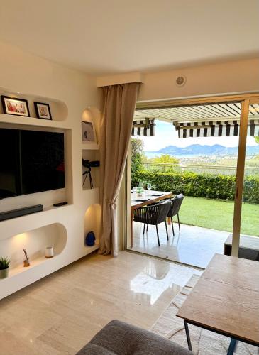 a living room with a television and a dining table at Garden sea view - Victoria - Le Cannet in Le Cannet