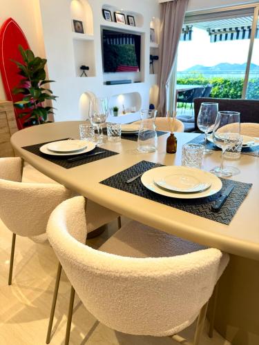 a dining room with a table with chairs and glasses at Garden sea view - Victoria - Le Cannet in Le Cannet