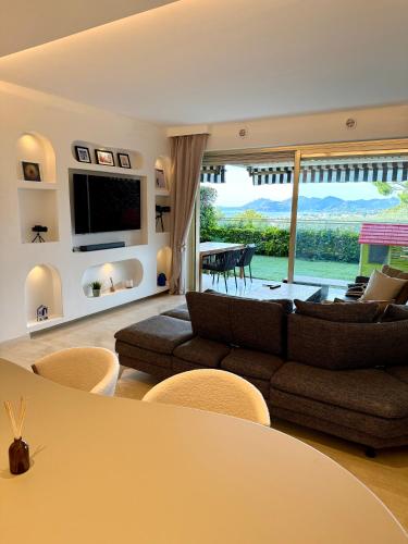 a living room with a couch and a large window at Garden sea view - Victoria - Le Cannet in Le Cannet