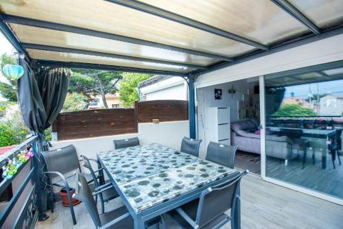 - un coin repas avec une table et des chaises sur la terrasse dans l'établissement L'Anisé - Maison climatisée, à Martigues