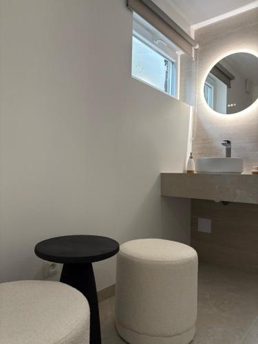 La salle de bains est pourvue d'une table, d'un tabouret et d'un lavabo. dans l'établissement Chez manu, à Voellerdingen