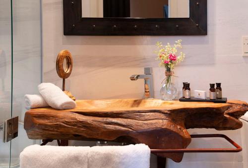 a bathroom with a wooden sink and a mirror at Sant Pere del Bosc Hotel & Spa - Adults Recommended in Lloret de Mar