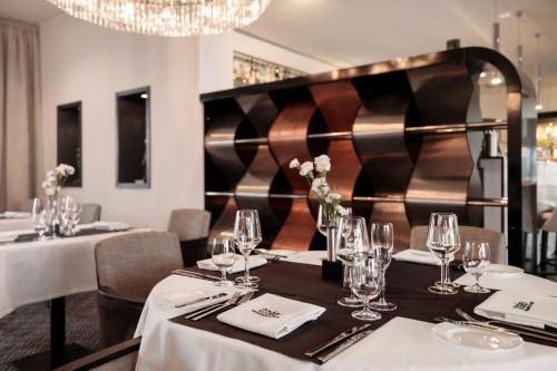 a dining room with tables with white tablecloths and glasses at Diune Hotel by Zdrojowa in Kołobrzeg