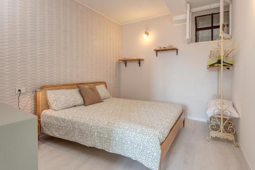 a small bedroom with a bed in a room at Appartamento gioiello vista lago in Perledo