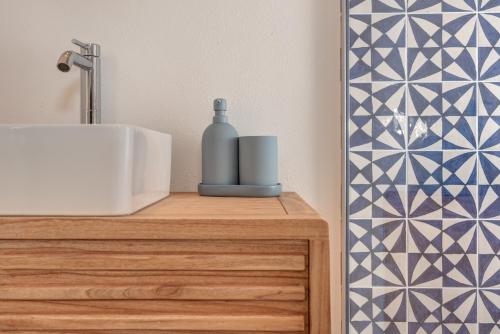 a bathroom with a sink and a bottle on a counter at Appartamento gioiello vista lago in Perledo