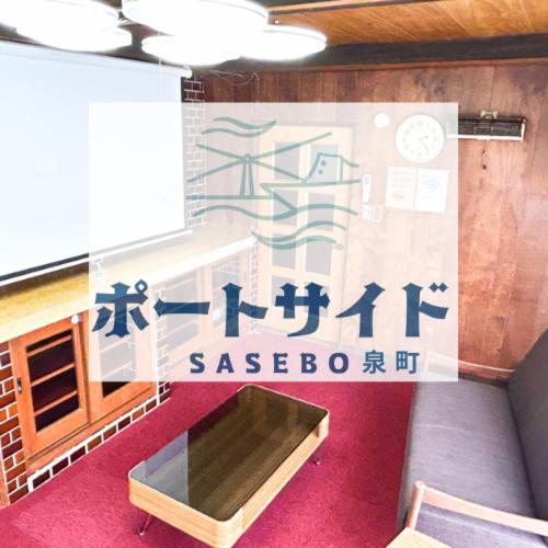 a room with a sign on the wall with a table at ポートサイドSasebo泉町 in Sasebo