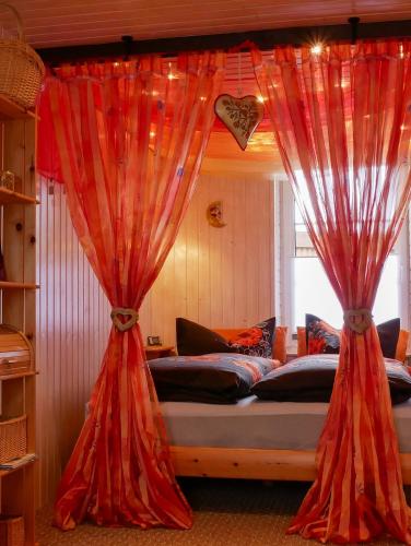 a bed with red curtains in a bedroom at Inselromantik Rügen, DZ Honeymoon in Dreschvitz