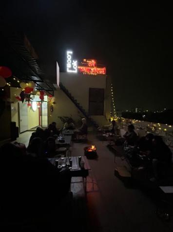 a group of people sitting around a building at night at Local Lok in Varanasi