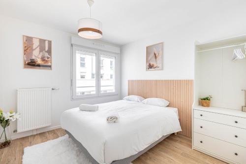 une chambre blanche avec un lit et une fenêtre dans l'établissement GuestReady - A Touch of Elegance in Romainville, à Romainville