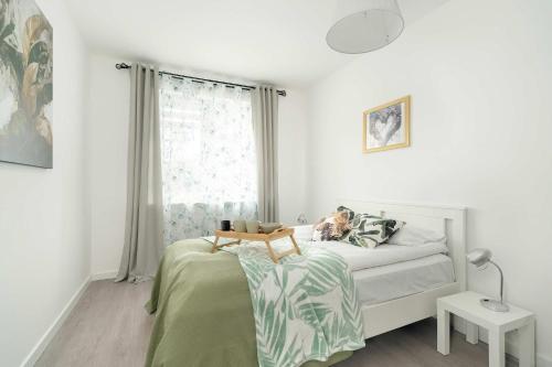 a bedroom with a bed with a dog sitting on it at Wyjątkowy Apartament z Balkonem by Noclegi Renters in Poznań