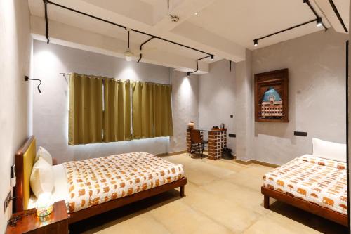 a room with two beds and a table and chairs at Local Lok in Varanasi