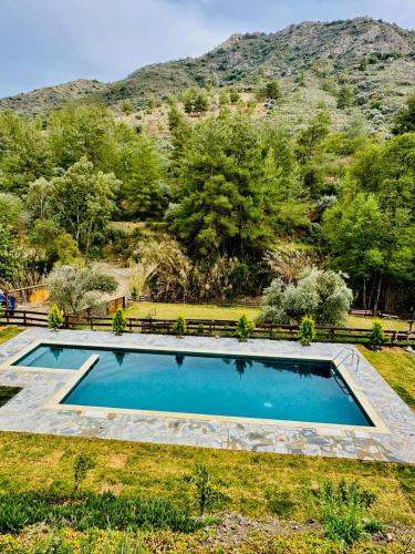 una piscina in erba con una montagna sullo sfondo di Mountain Glamping Cabin With Kids Playground and Pool a Arakapas