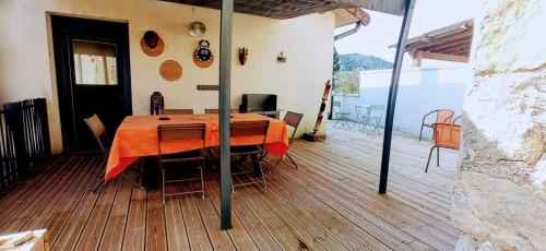 une chambre avec une table et des chaises sur une terrasse dans l'établissement La Paus'Tilleul, à Dunières-sur-Eyrieux