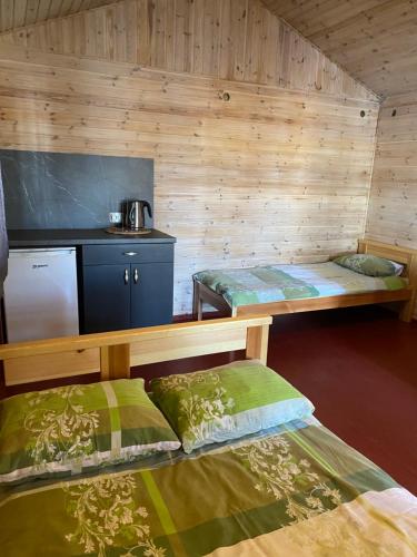 a small room with two beds and a kitchen at Kempings Bejas in Babīte