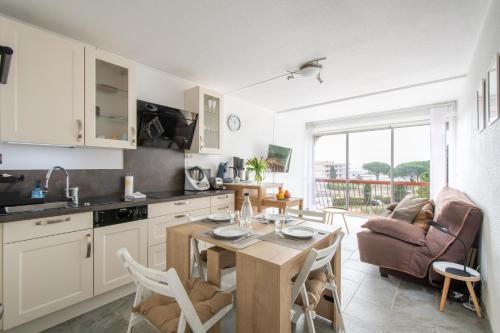 une cuisine et un salon avec une table et des chaises dans l'établissement Escale au Boucanet - A 150m de la plage, au Grau-du-Roi