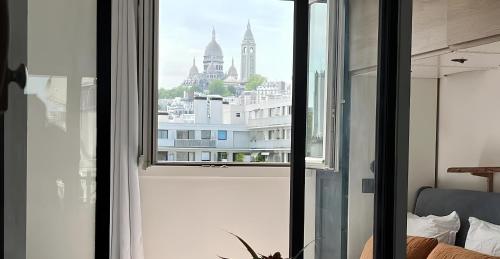 Elle offre une vue sur les toits de la ville depuis sa fenêtre. dans l'établissement Superbe Loft avec Vue Incroyable sur Montmartre, à Paris