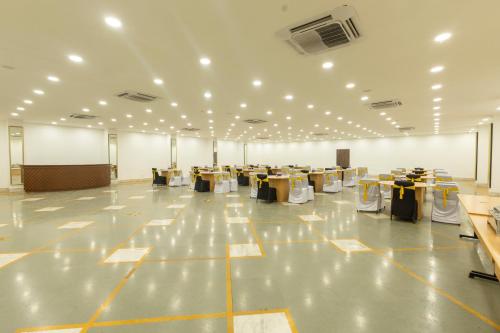 a large room with tables and chairs and lights at The Metropole by Keyboard Hotels in Lonavala