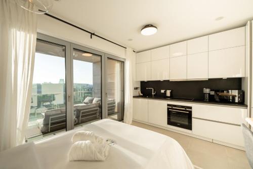 a large white bathroom with a tub and a kitchen at Modern Studio in Gasperich with Balcony & Wi-Fi in Luxembourg