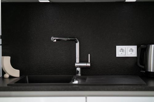 a kitchen sink with a faucet on a counter at Modern Studio in Gasperich with Balcony & Wi-Fi in Luxembourg