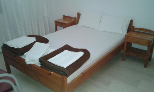 a bed with a wooden frame with two nightstands and acknowled at Pension Kyriakos in Plakias