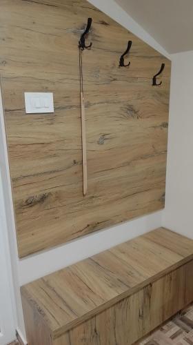 a wooden wall with a clock in a room at Apartman Dve lipe in Palić